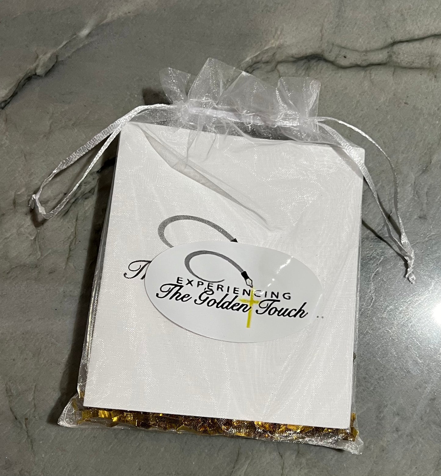 comes packaged in a white organza bag with gold shreds