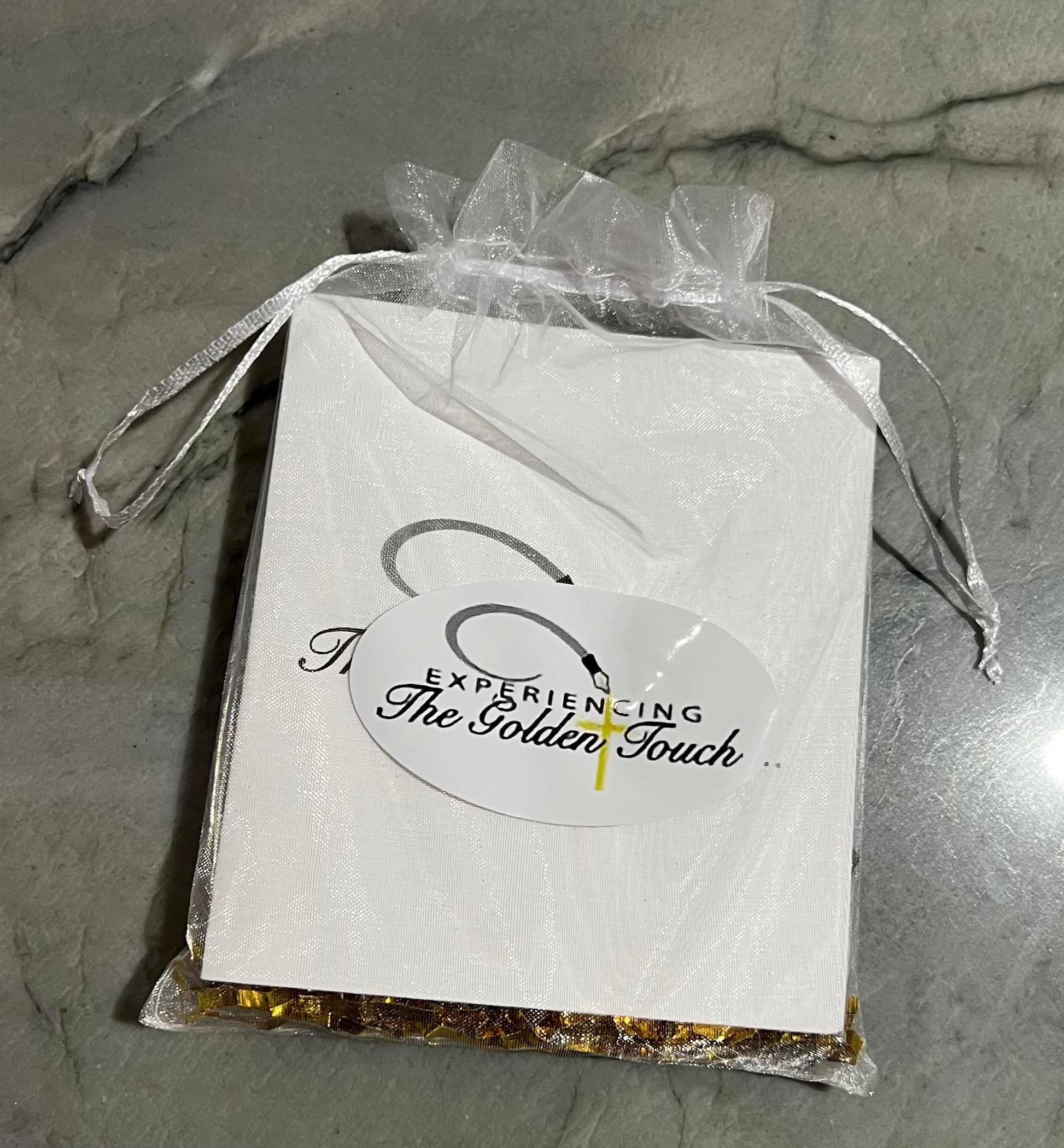comes packaged in a white organza bag with gold shreds